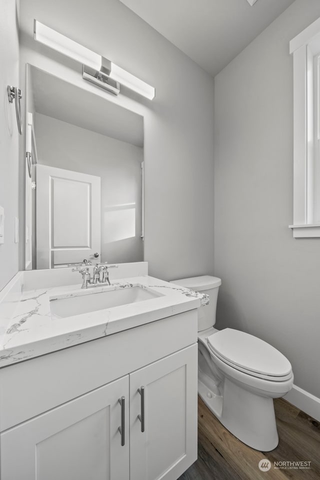 bathroom with hardwood / wood-style flooring, vanity, and toilet