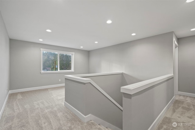 hallway with light colored carpet