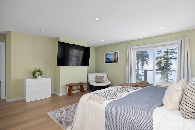 bedroom with access to exterior and light hardwood / wood-style flooring