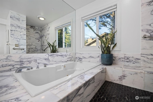 bathroom featuring a relaxing tiled tub and tile walls