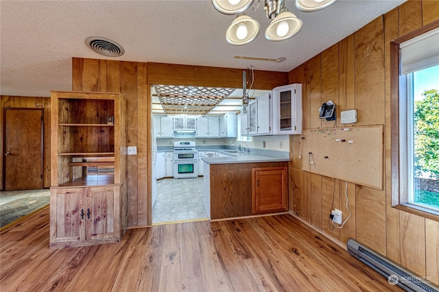 kitchen with sink, white cabinetry, a baseboard radiator, double oven range, and light hardwood / wood-style floors