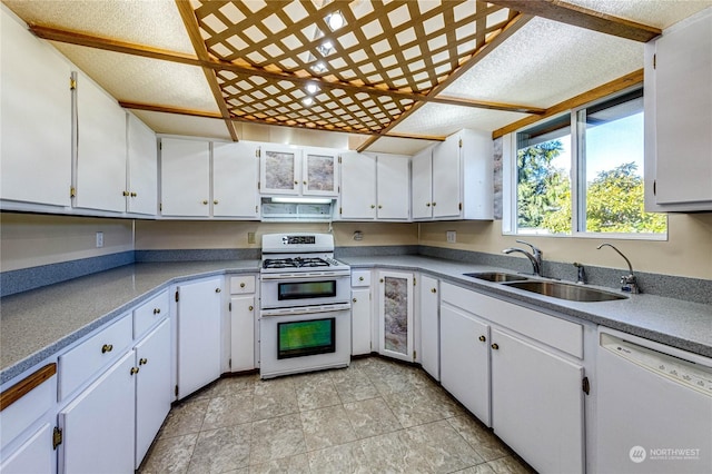 kitchen featuring double oven range, dishwasher, sink, and white cabinets