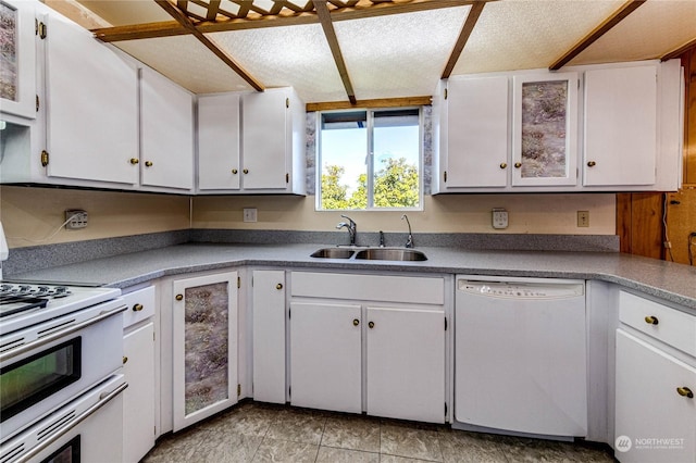 kitchen featuring sink, white appliances, a textured ceiling, and white cabinets