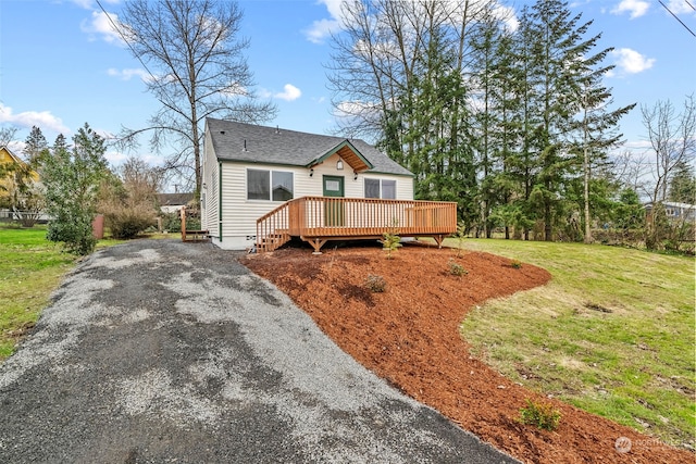 view of front of property with a wooden deck and a front yard