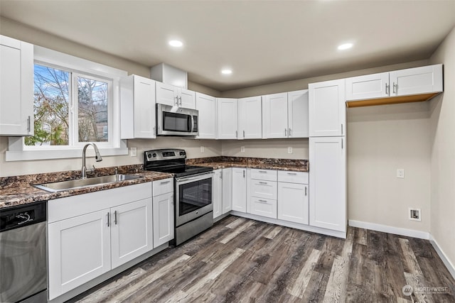 kitchen featuring sink, dark wood-type flooring, stainless steel appliances, and white cabinets