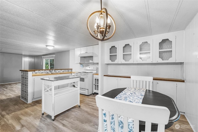 kitchen with white cabinetry, a kitchen island, pendant lighting, and white electric range