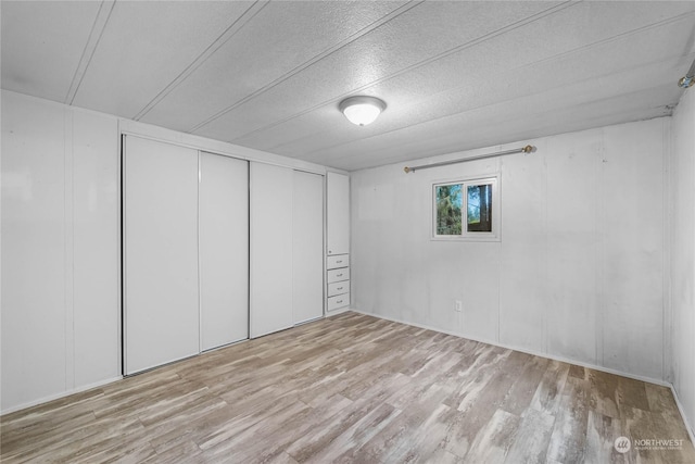 unfurnished bedroom with a closet and light hardwood / wood-style flooring