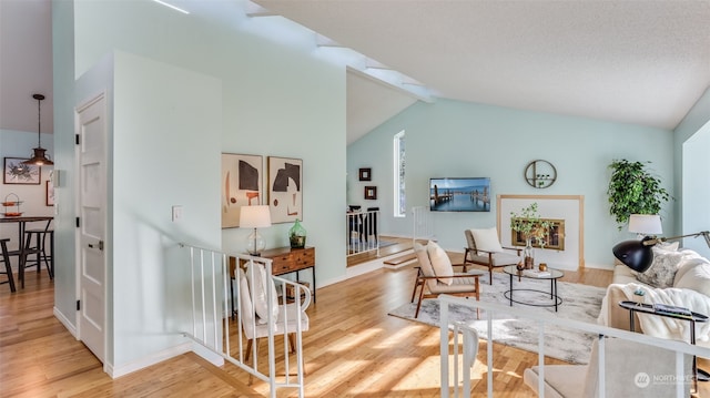 living room featuring lofted ceiling and light hardwood / wood-style flooring