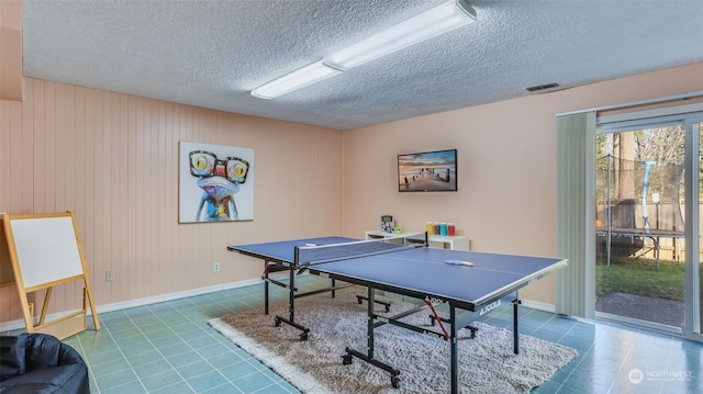 playroom with tile patterned floors and a textured ceiling