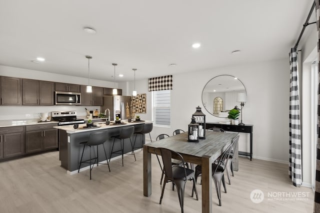 dining area featuring recessed lighting, light wood-style flooring, and baseboards