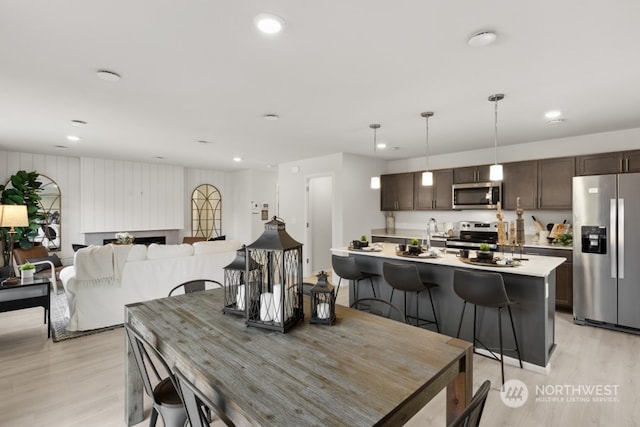 dining area with recessed lighting, a fireplace, and light wood-style floors