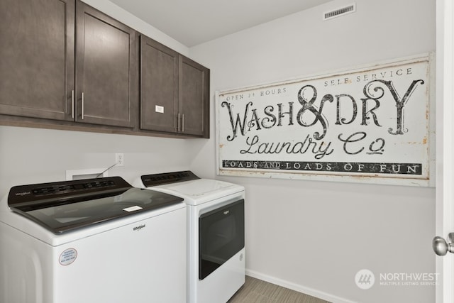 laundry room featuring cabinet space, visible vents, washing machine and dryer, and baseboards