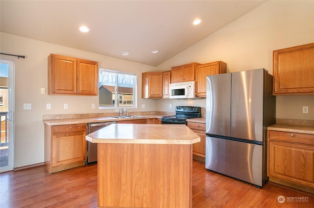 kitchen featuring appliances with stainless steel finishes, light hardwood / wood-style floors, sink, and a kitchen island