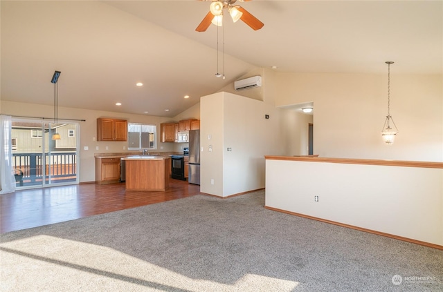 kitchen featuring appliances with stainless steel finishes, pendant lighting, sink, a center island, and a wall unit AC