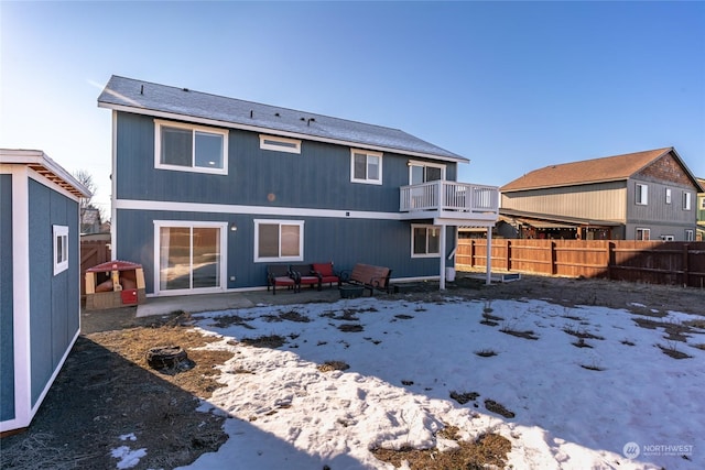 snow covered rear of property featuring a balcony