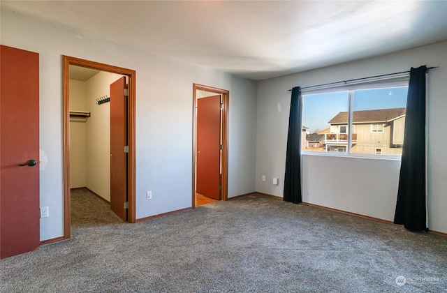 unfurnished bedroom with a walk in closet and carpet floors