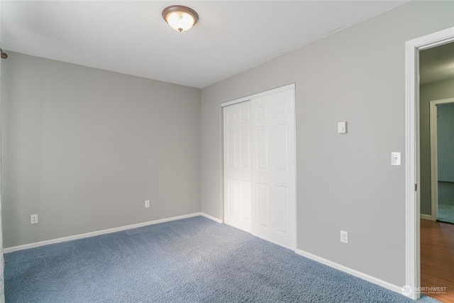 unfurnished bedroom featuring carpet and a closet