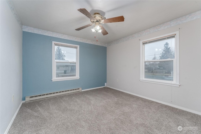 carpeted spare room with ceiling fan and a baseboard heating unit