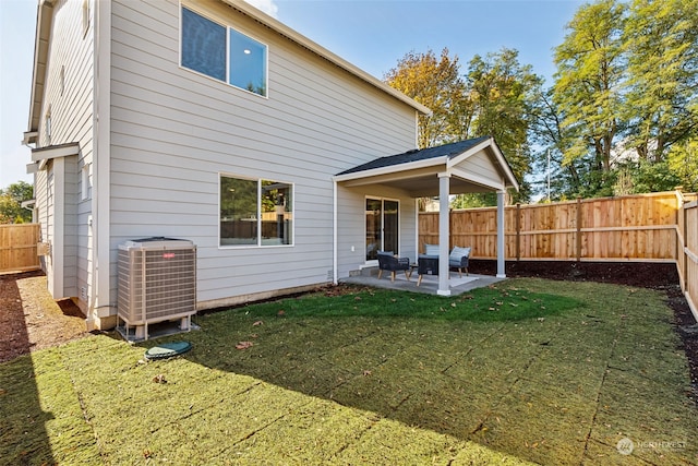 rear view of property with central AC, a patio, and a lawn