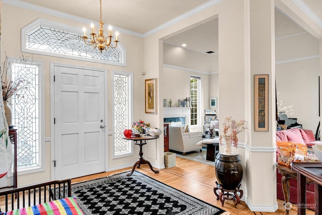 foyer featuring hardwood / wood-style flooring, crown molding, and a notable chandelier