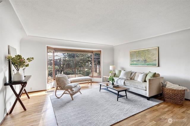 living room with light hardwood / wood-style floors and a textured ceiling