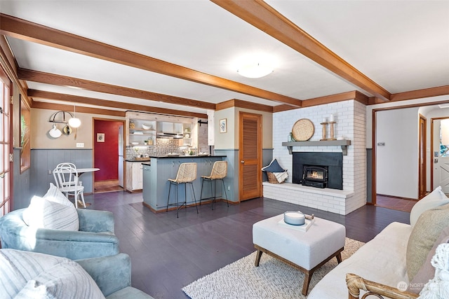 living room featuring a fireplace, dark hardwood / wood-style floors, and beam ceiling