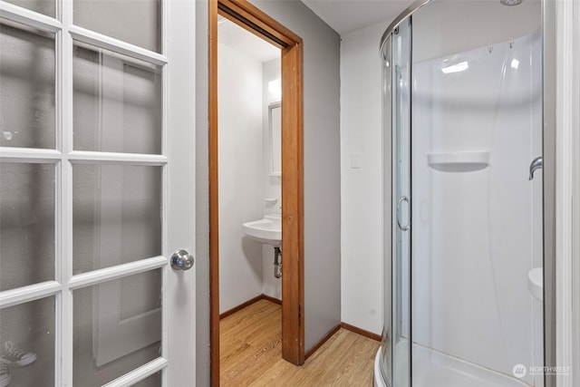 bathroom with sink, hardwood / wood-style flooring, and walk in shower