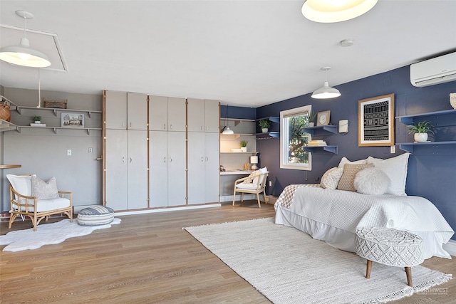 bedroom featuring a wall unit AC and light hardwood / wood-style floors