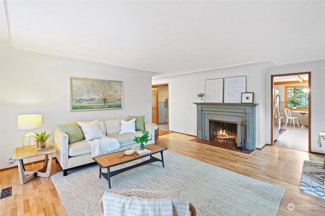 living room with hardwood / wood-style flooring and a brick fireplace