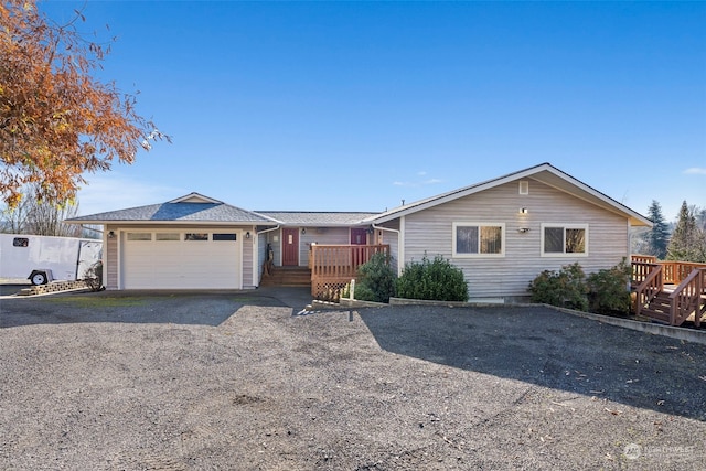 single story home featuring a wooden deck and a garage