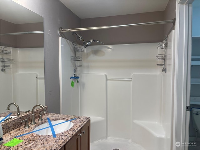 bathroom with walk in shower and vanity