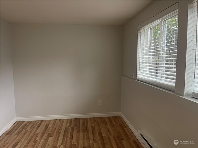 spare room with hardwood / wood-style flooring and a baseboard radiator