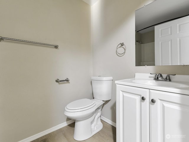 bathroom featuring vanity, hardwood / wood-style floors, and toilet