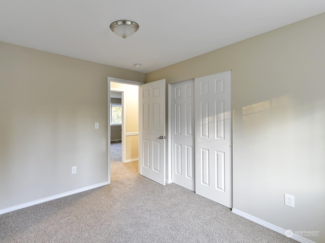 unfurnished bedroom featuring light carpet and a closet