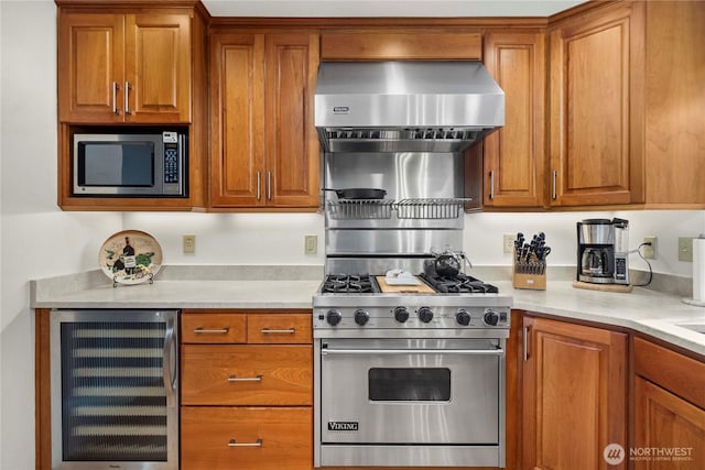 kitchen featuring beverage cooler, brown cabinets, stainless steel appliances, and wall chimney exhaust hood