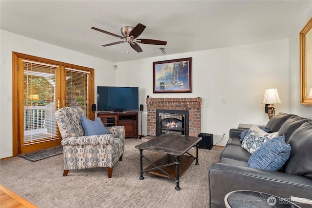 living area featuring ceiling fan and a fireplace