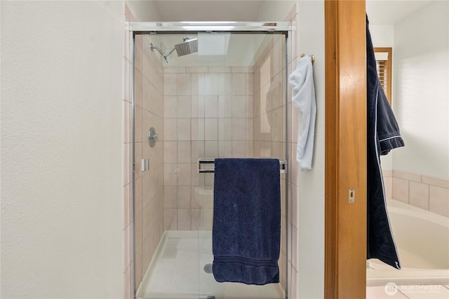 full bathroom featuring a shower stall and a tub to relax in