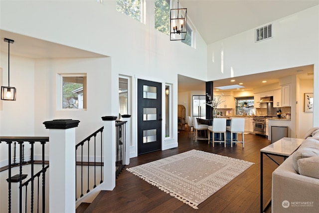 foyer featuring dark wood-type flooring, a healthy amount of sunlight, and a notable chandelier