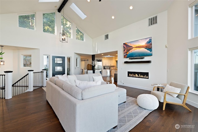 living room with dark hardwood / wood-style flooring, a skylight, high vaulted ceiling, and beam ceiling