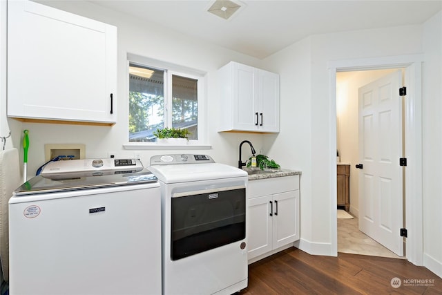 laundry room featuring cabinets, sink, dark hardwood / wood-style floors, and washing machine and dryer