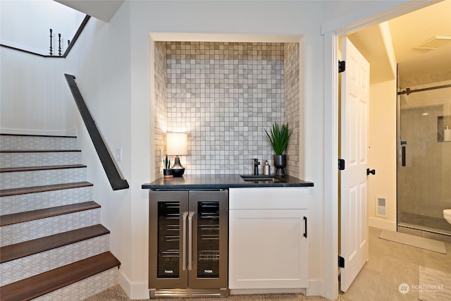 bar with white cabinetry, beverage cooler, sink, and decorative backsplash