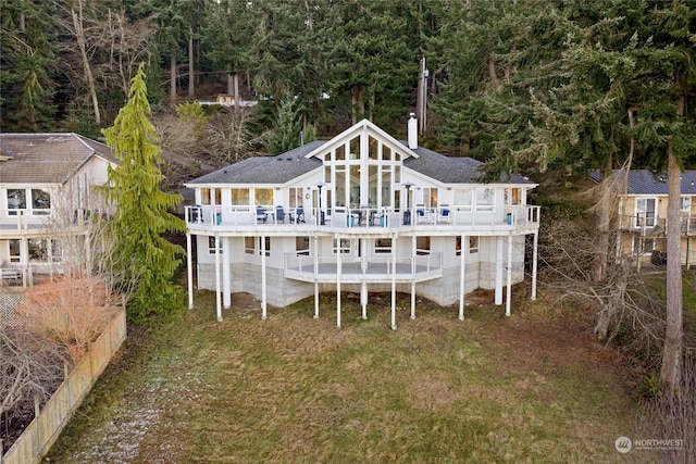 back of property featuring a wooden deck and a yard