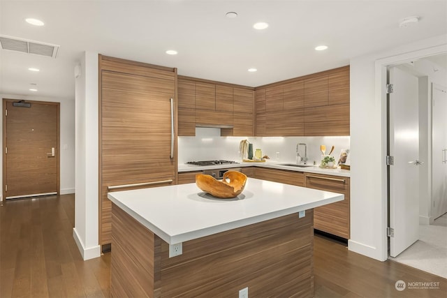 kitchen featuring dark hardwood / wood-style flooring, sink, and a center island