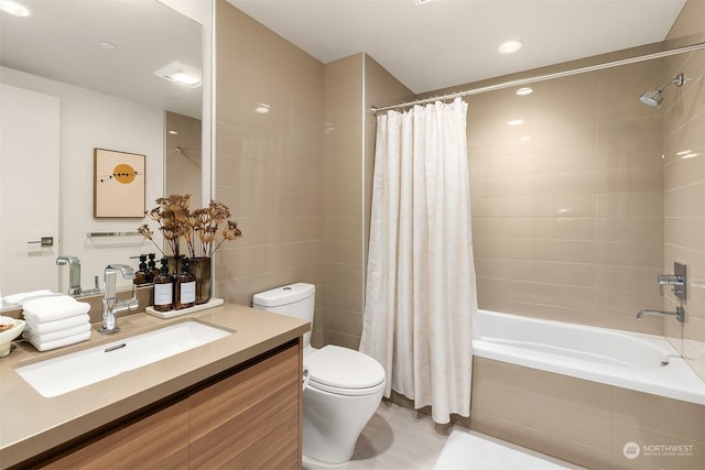 full bathroom with toilet, vanity, shower / bathtub combination with curtain, and tile walls