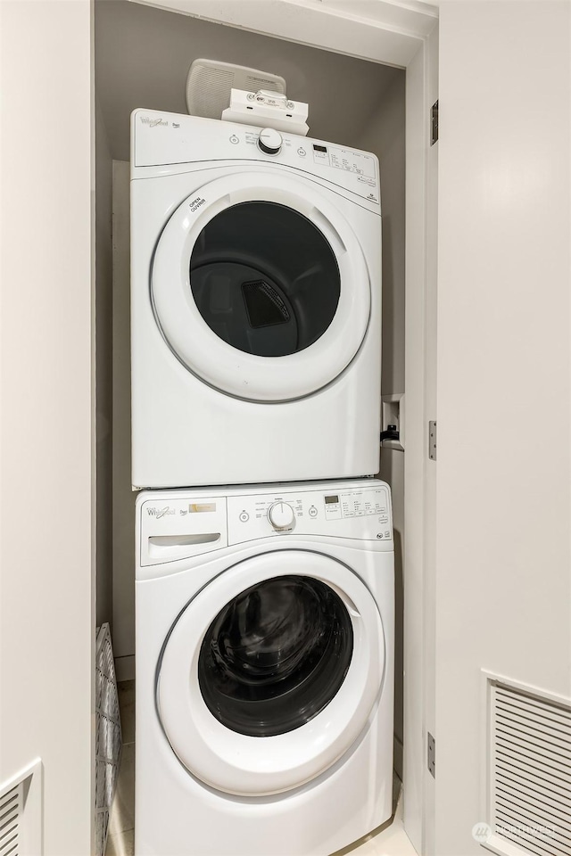 clothes washing area featuring stacked washing maching and dryer