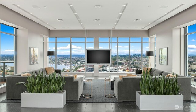 living room with dark hardwood / wood-style flooring and a water view