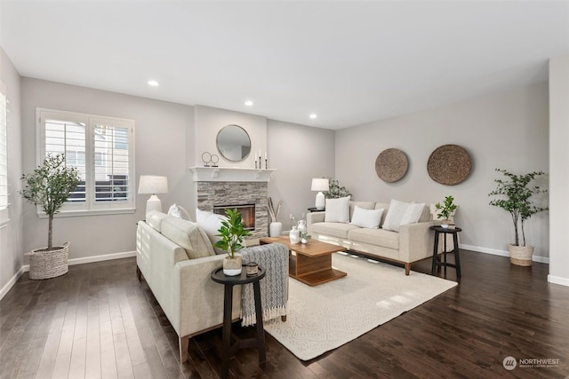 living room with a stone fireplace and dark wood-type flooring