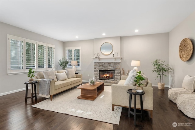 living room featuring a stone fireplace and dark hardwood / wood-style floors