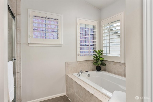 bathroom with a relaxing tiled tub