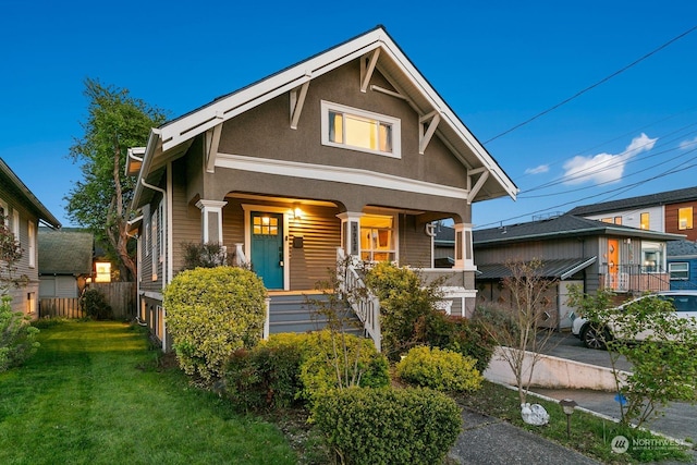 view of front of home featuring covered porch and a front lawn